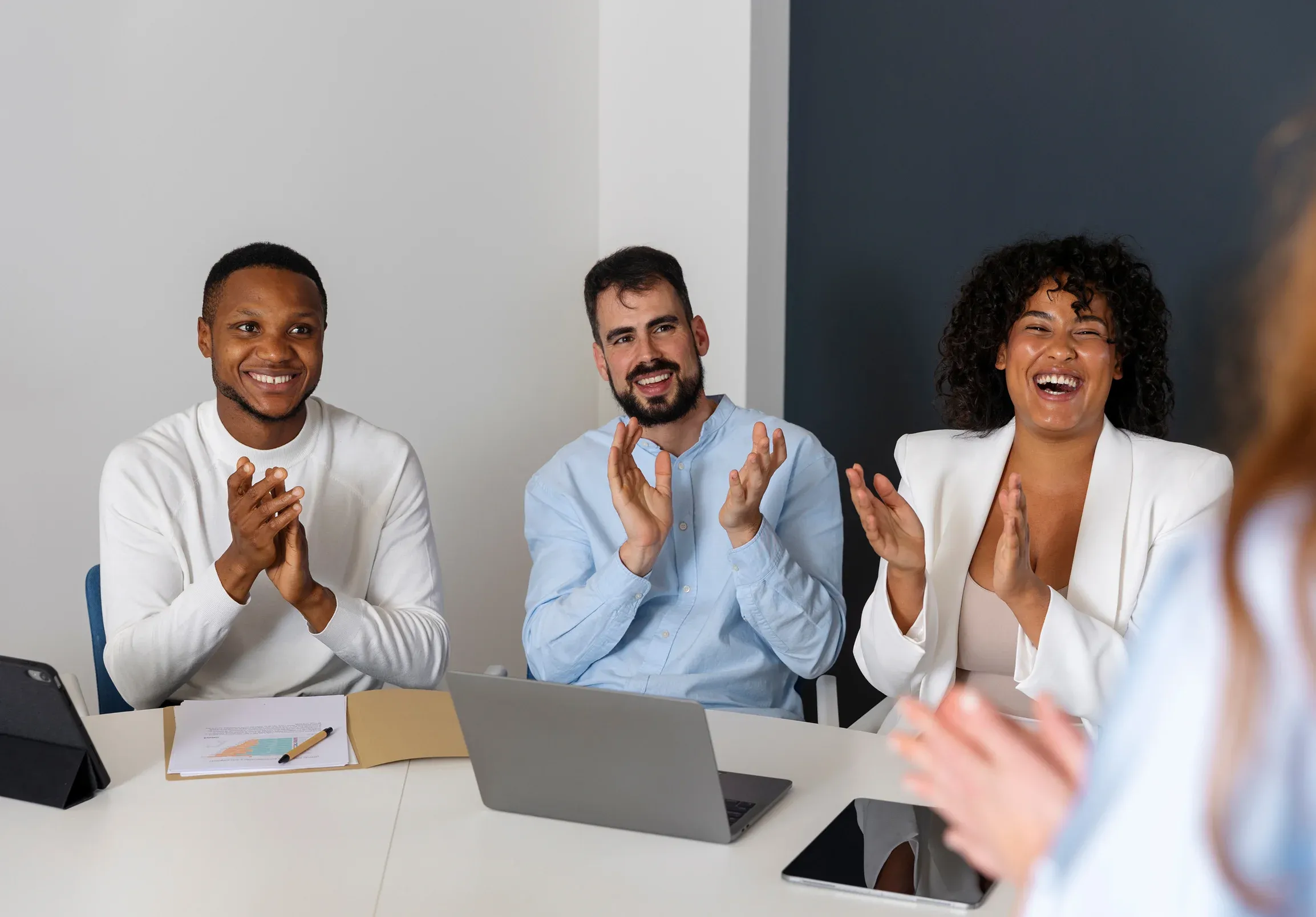 Collaborateurs applaudissant autour d’un ordinateur