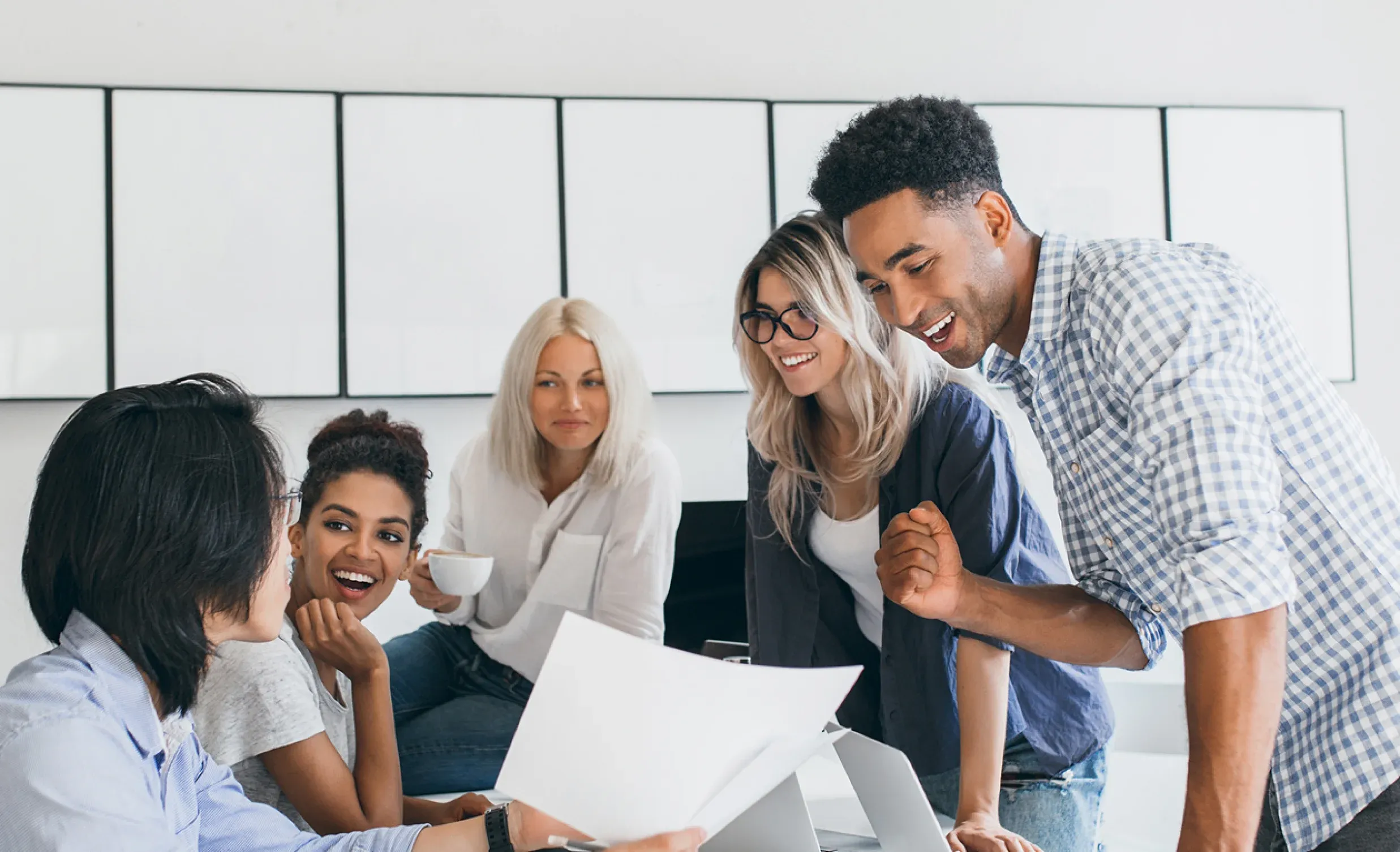 Équipe souriante réunie autour d’un document
